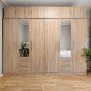 A bedroom with a bed and a wooden closet